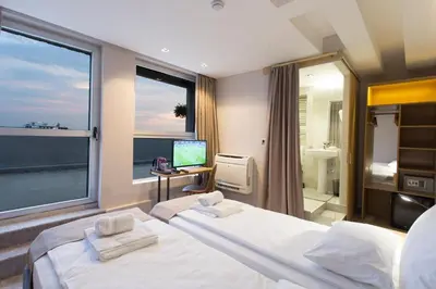 a bedroom with two beds and a large window at Prince Rooftop in Belgrade