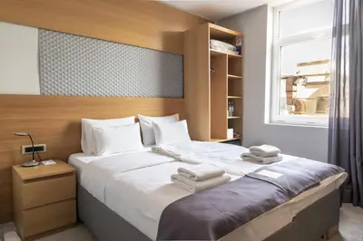 a bedroom with a large bed with towels on it at Prince Rooftop in Belgrade