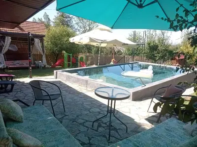 a pool with chairs and a table and an umbrella at Sava Land in Belgrade