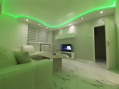 a living room with a couch and a table and a tv at Apartman brdo in Belgrade