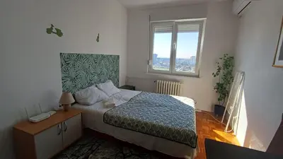 a bedroom with a bed and a window at Sobe AURORA Nehruova 82 in Belgrade
