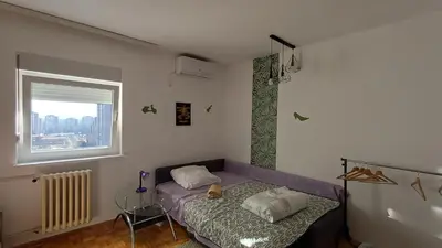 a bedroom with a purple bed and a window at Sobe AURORA Nehruova 82 in Belgrade