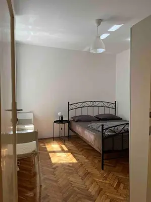 a bedroom with a bed and a wooden floor at Central Home in Belgrade in Belgrade