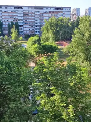a group of trees in front of a building at Magenta New Belgrade in Belgrade