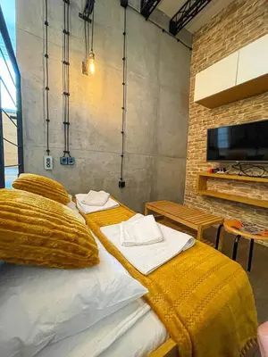 a bedroom with a bed with a yellow blanket at Downtown Heaven in Belgrade