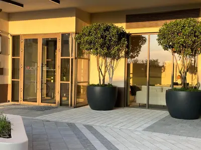 two large pots with trees in them in front of a building at THE GATES 210 in Belgrade