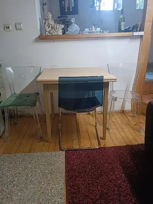 a wooden table with a blue chair and a table and a stool at Maravilja in Filmski Grad