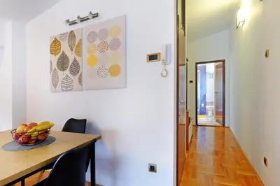a dining room table with a bowl of fruit on it at Red Tree Apartment in Belgrade