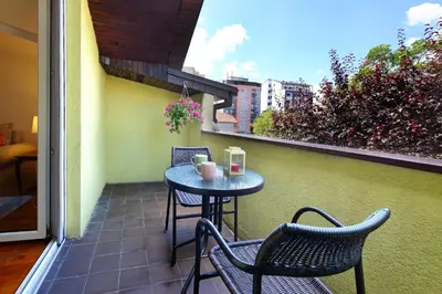 a small table and chairs on a balcony at Red Tree Apartment in Belgrade