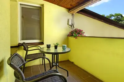 a small table and two chairs on a balcony at Red Tree Apartment in Belgrade