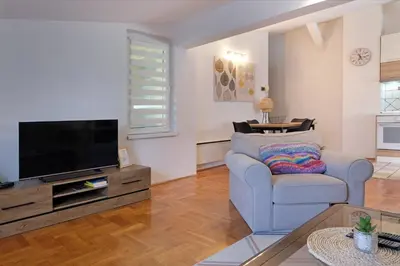 a living room with a couch and a flat screen tv at Red Tree Apartment in Belgrade
