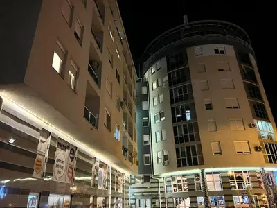 two tall buildings next to each other at night at Apartman Maja in Ruma