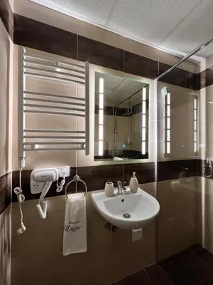 a bathroom with a sink and a mirror and a tub at Apartman Maja in Ruma