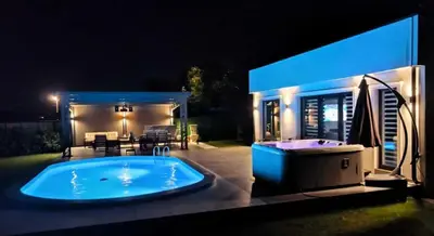 a large hot tub in front of a house at night at Vila Grof in Vinča
