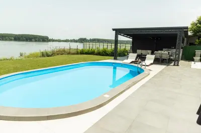 a swimming pool in a backyard with a view of the water at Vila Grof in Vinča