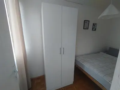 a small bedroom with a bed and a closet at Apartman Vuković in Novi Beograd