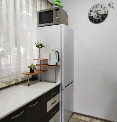 a kitchen with a refrigerator and a clock on a wall at Astra M in Vračar (historical)