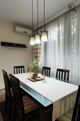 a dining room table with chairs and a white tablecloth at Astra M in Vračar (historical)