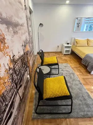 a room with two chairs and a bed at Tesla View Apartment in Belgrade