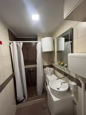 a bathroom with a sink and a toilet and a mirror at Tesla View Apartment in Belgrade