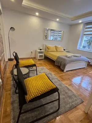 a bedroom with two beds and a table and chairs at Tesla View Apartment in Belgrade