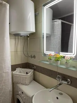 a bathroom with a sink and a mirror and a washing machine at Tesla View Apartment in Belgrade