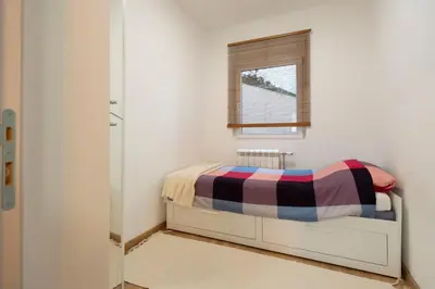 a small bedroom with a bed and a window at 1-bedroom apartment near airport in Surčin