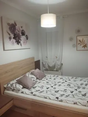a bedroom with a bed and a light and a lamp at Manila Apartment in Belgrade
