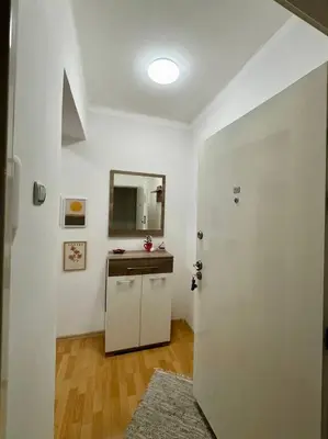 a white bathroom with a sink and a mirror at Manila Apartment in Belgrade