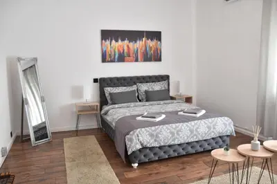 a bedroom with a bed and two tables and a mirror at Apartment in Belgrade with small parking space in Belgrade