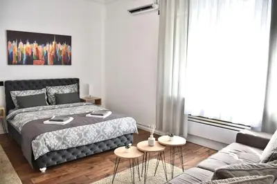 a bedroom with a bed and two tables at Apartment in Belgrade with small parking space in Belgrade
