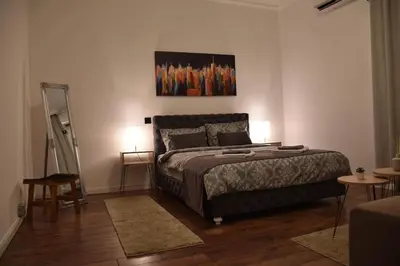 a bedroom with a bed with two tables and two lamps at Apartment in Belgrade with small parking space in Belgrade