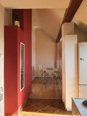 a kitchen and dining room with a red wall at Belgrade Loft Apartments in Novi Beograd