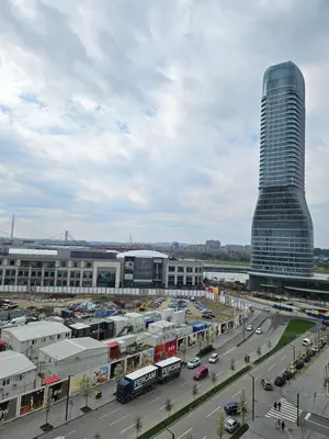 a city with a tall building and a parking lot at Best Apartments-Aqua-Belgrade Waterfront in Belgrade
