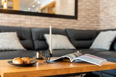 a coffee table with a book and a candle and croissants at 1-Bedroom Apartment with Balcony in Ledine