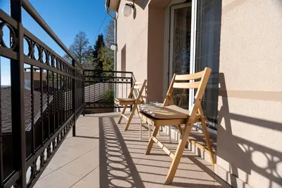 two chairs sitting on the porch of a house at 1-Bedroom Apartment with Balcony in Ledine