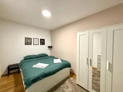 a white bedroom with a bed and a closet at 7 Emperors Central Suite in Belgrade