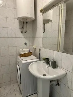a white bathroom with a sink and a mirror at 7 Emperors Central Suite in Belgrade