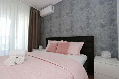 a bedroom with a large bed with pink pillows at Savada PINK - studio with parking and WiFi, parking 5 eur per day in Belgrade