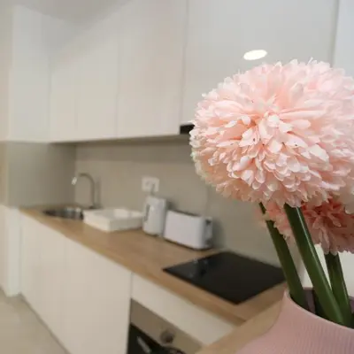 a vase with a large pink flower in a kitchen at Savada PINK - studio with parking and WiFi, parking 5 eur per day in Belgrade