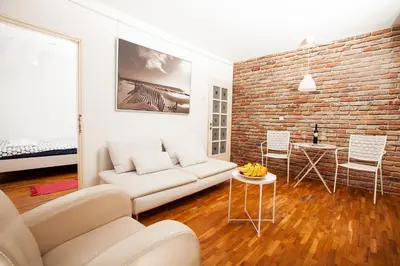 a living room with a white couch and a brick wall at Dorcol Rooftop Apartment in Belgrade