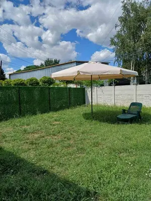 an umbrella and a chair in the grass at Garden Apartment New Belgrade in Novi Beograd