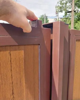 a hand is putting a piece of metal on a fence at Garden Apartment New Belgrade in Novi Beograd