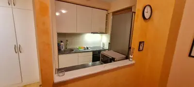 a small kitchen with white cabinets and a clock at Amar5 in Belgrade