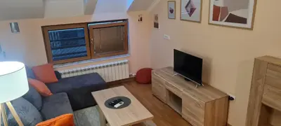 a living room with a blue couch and a television at Amar5 in Belgrade
