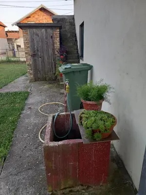 a container with plants in it next to a trash can at Surcin center house in Surčin