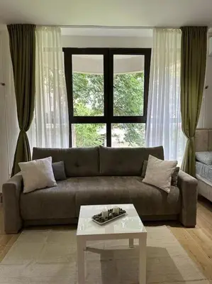 a living room with a couch and a table and a window at BeGreat in Belgrade