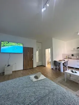 a white bedroom with a large bed and a table at BeGreat in Belgrade