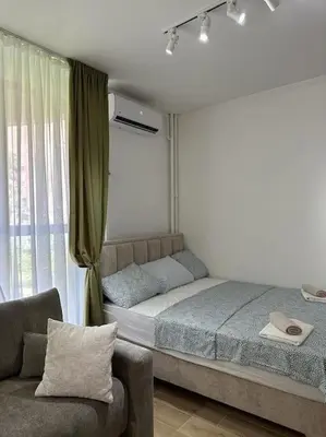 a bedroom with a bed and a chair and a window at BeGreat in Belgrade