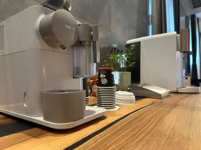 a mixer sitting on a counter with a stack of plates at KAME HOTEL BELGRADE,\u8d1d\u5c14\u683c\u83b1\u5fb7\u51ef\u7f8e\u9152\u5e97 in Ledine